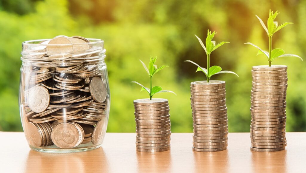 A jar of coins and a pile of coins with plants growing on top to indicate saving money or money growing Through changing carrier to Rakutewn Mobile