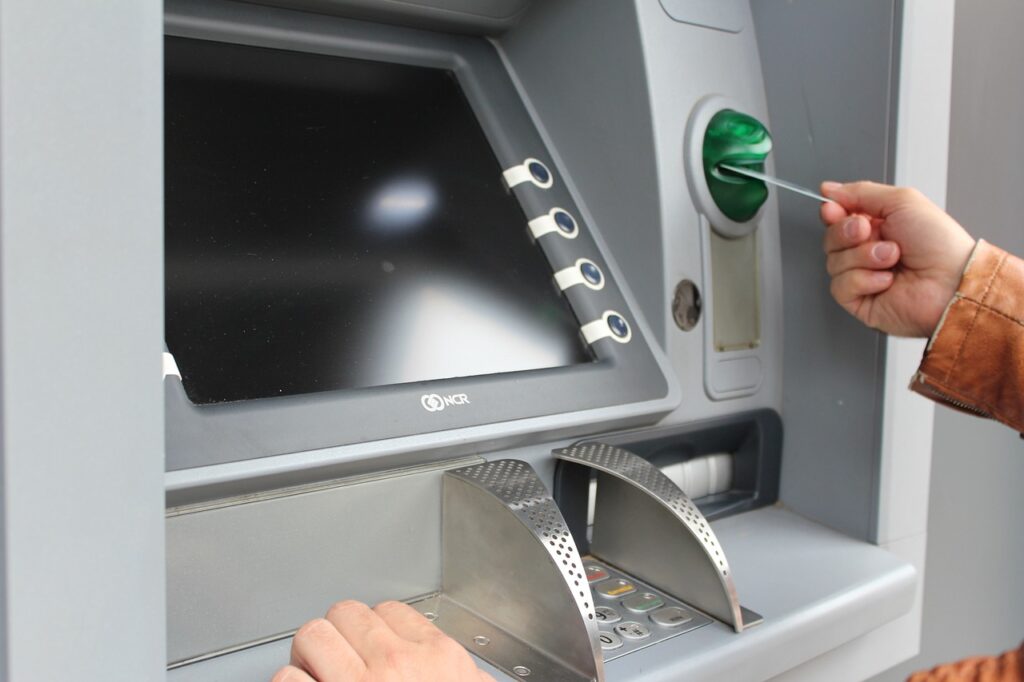 A person using An Atm machine to indicate how to use on how to use an atm in Japan