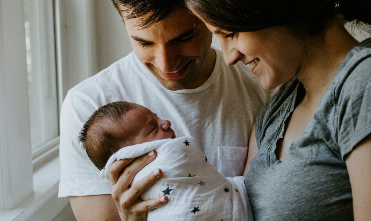 A man and woman holding a baby to indicate Understanding Parental Leave