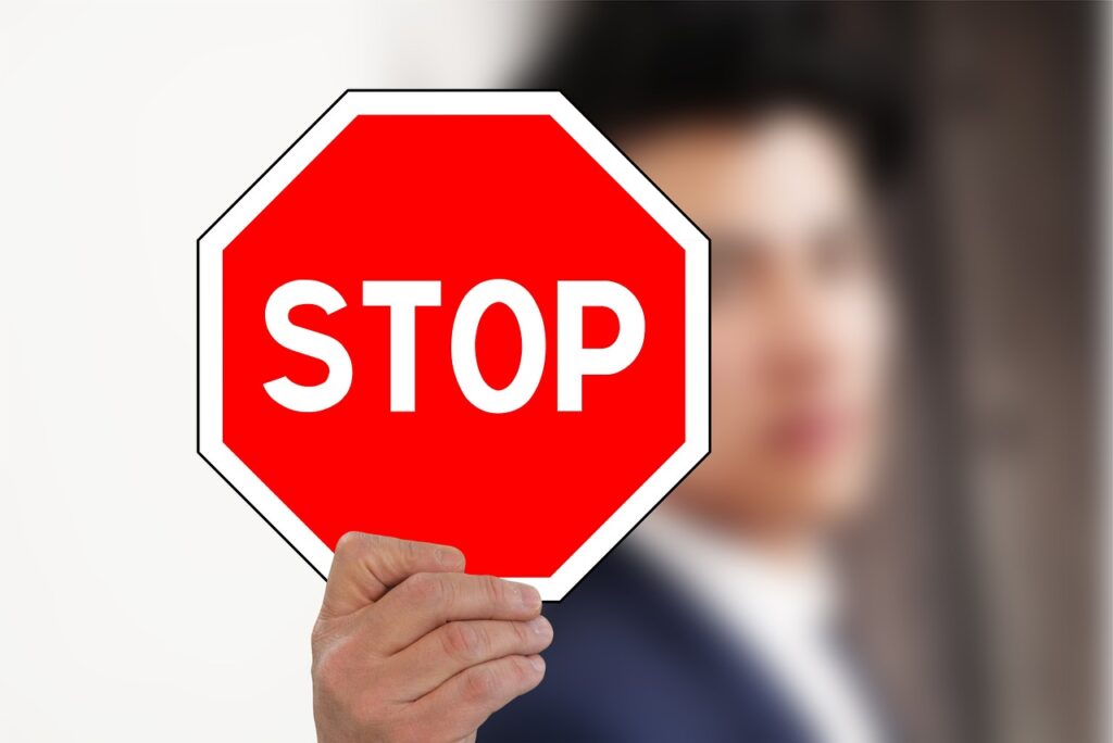 a man holding a stop sign to indicate things to avoid when changing jobs in japan