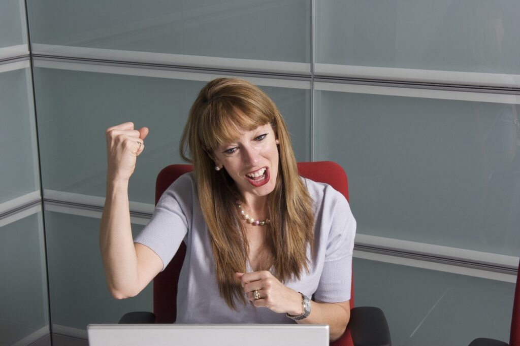 A woman sitting in a chair doing a success gesture  because she answered how to find a job in japan as a foreigner