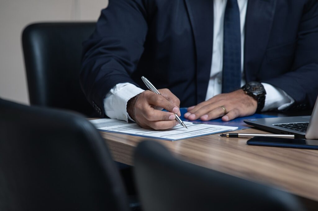 a man in a suit writting on a paper