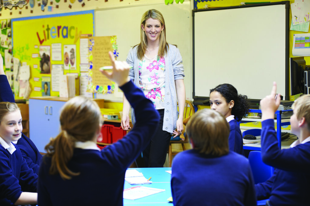 A female teacher teaching a class of kids to showcase being a teacher that is working in Japan after getting a Working Visa in Japan