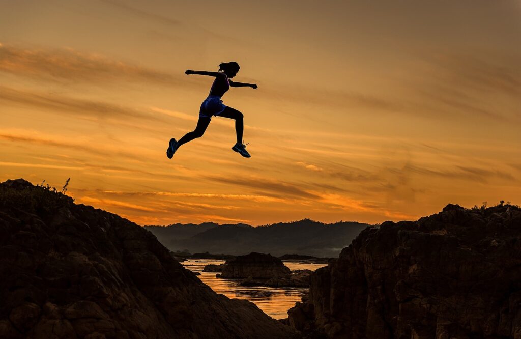 a woman jumping over a cliff to indicate Visa Job Restrictions challenges